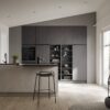 Häcker Designküche mit Halbinsel Zement, grifflose Fronten in Zementoptik